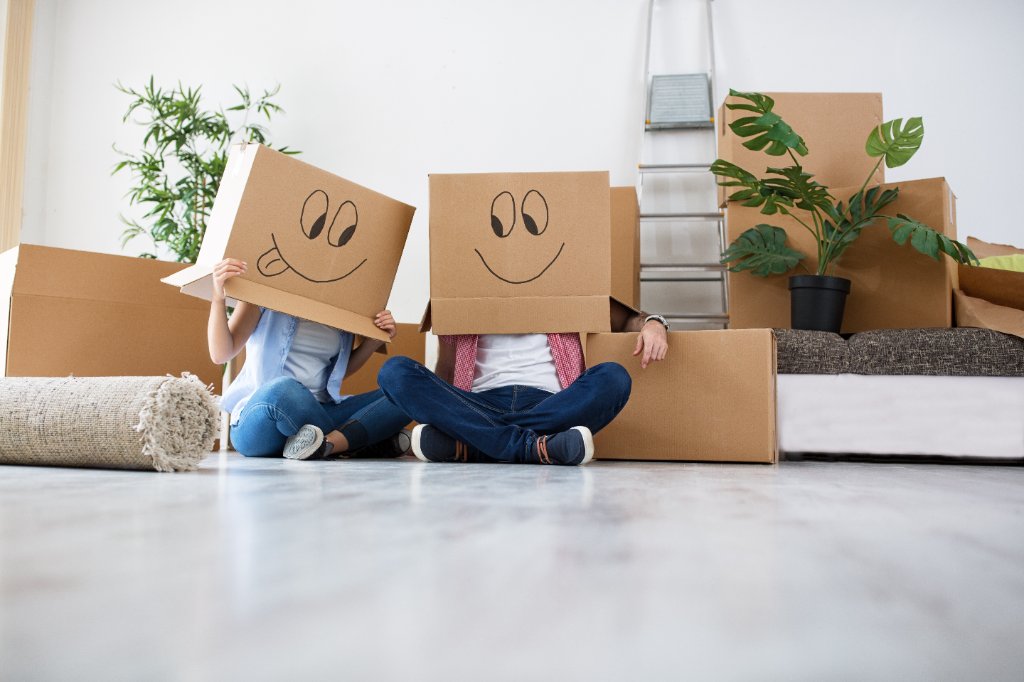 Happy couple moving into their new home surrounded by boxes
